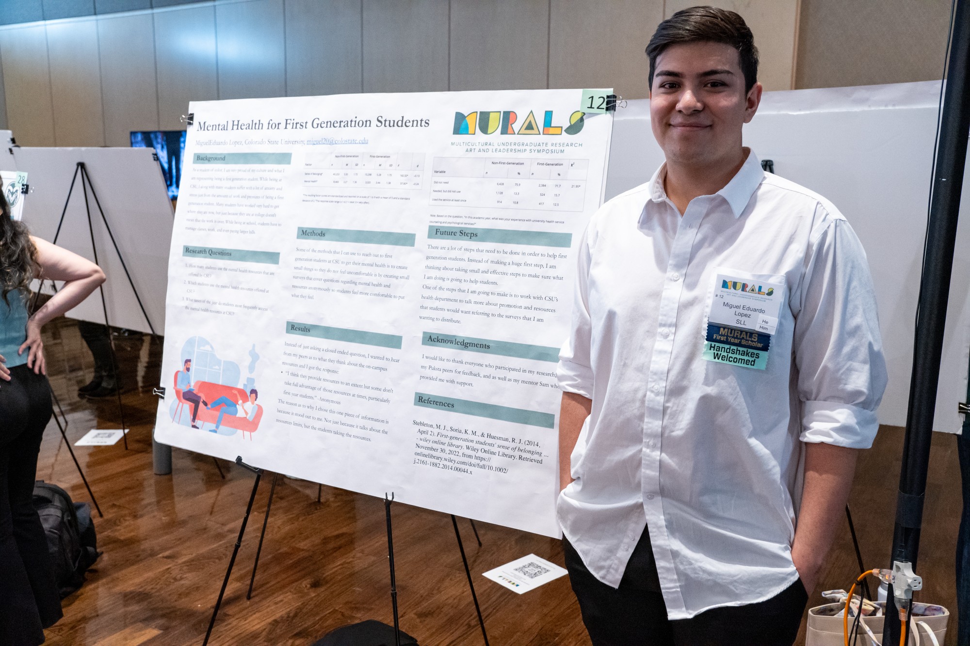 Participating student standing beside their showcase poster and work at the 2023 MURALS symposium in CSU's Lory Student Center.