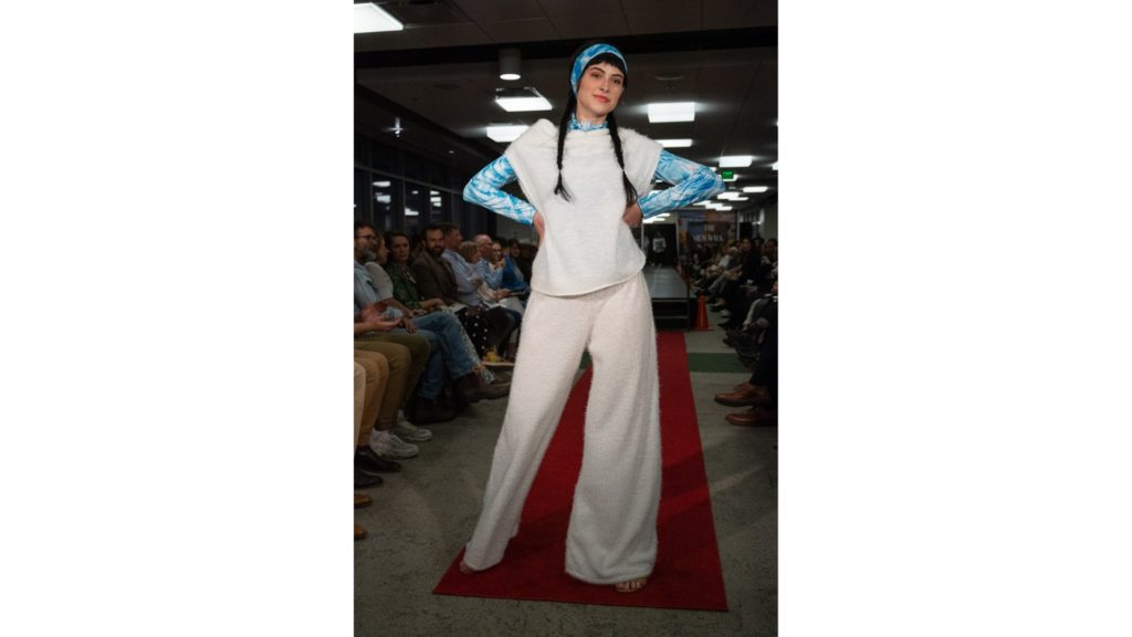 A student at the CSU fashion show is pictured modeling a white and powder blue outfit