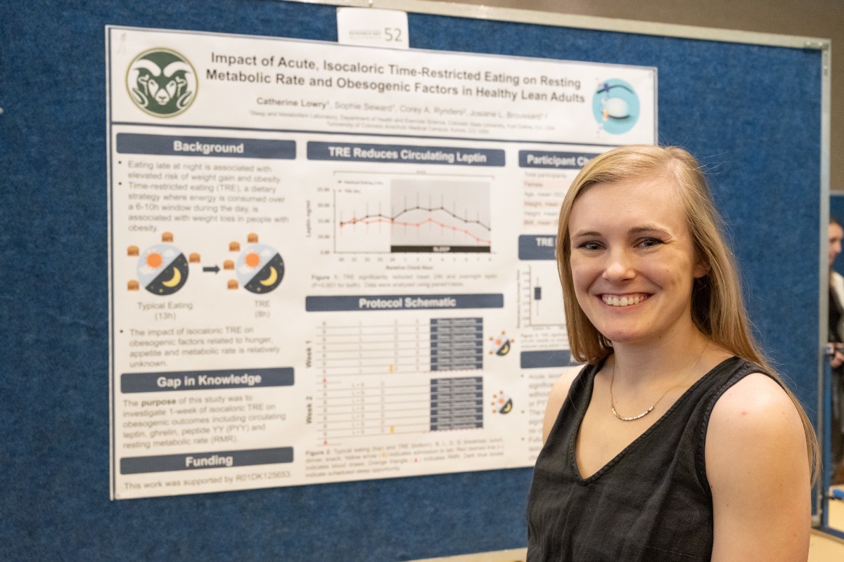 Catherine Lowry standing in front of her research poster