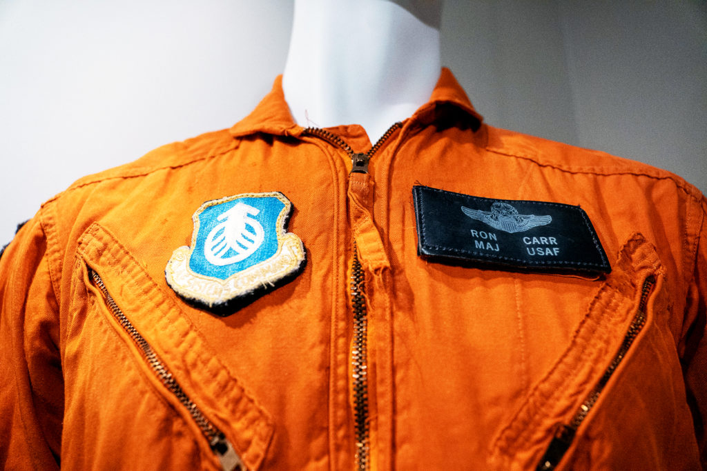 Snapshots: Six Curatorial Concepts includes an orange vest and name patch.