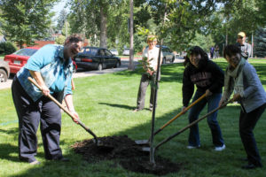 Karen Atler helping Yamagata students plant a tree outside the occupational therapy building