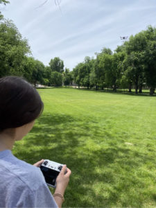 Student with remote control flying a drone on CSU Oval