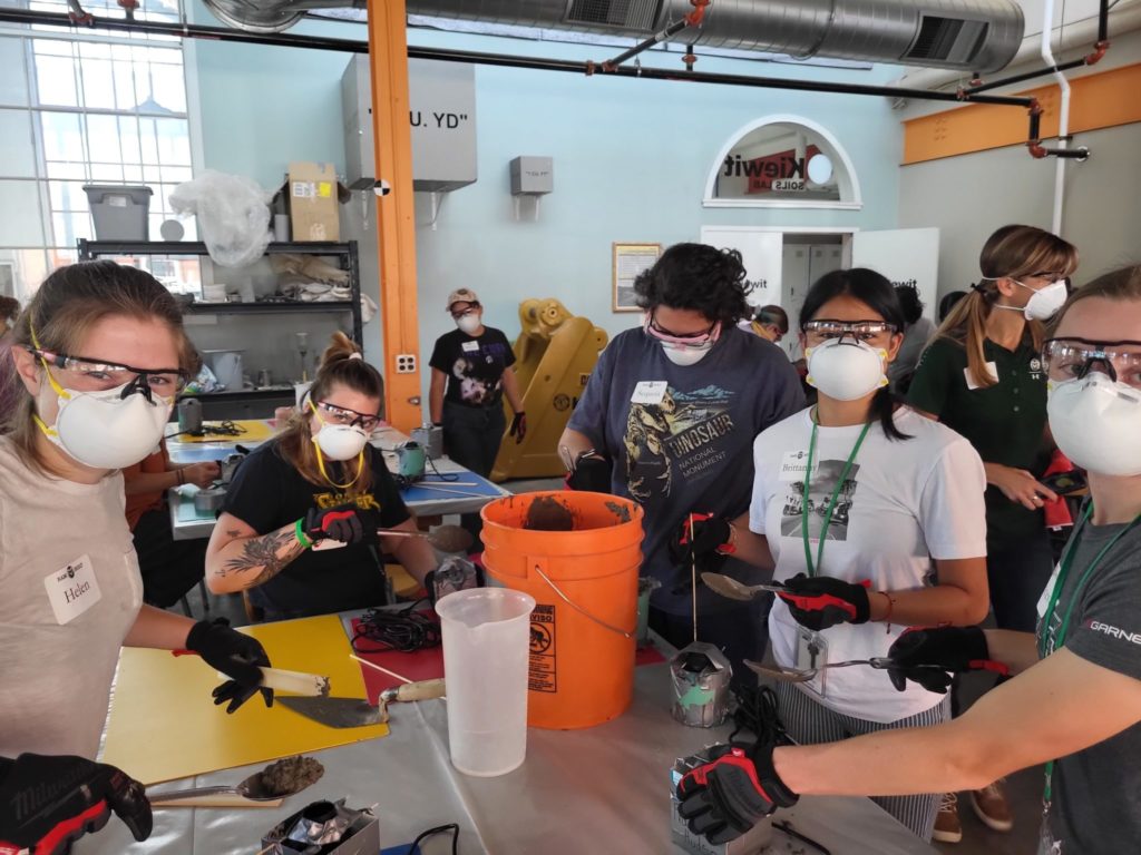 Young women in lab with protective masks mixing concrete