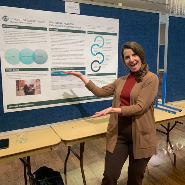 Paula Yuma posing with her research poster