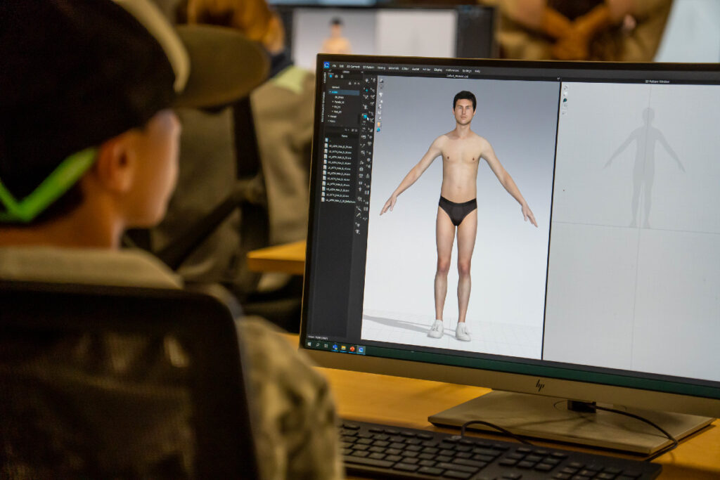 A student looking at a screen showing a male in a body modeling program