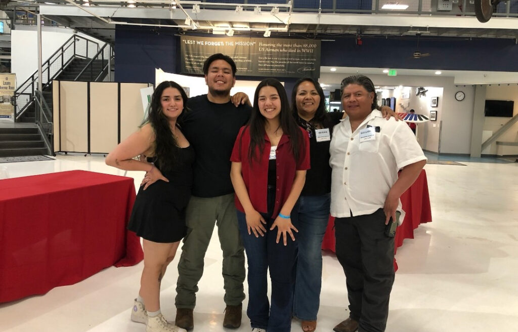 Lesly, in red, standing with her family.