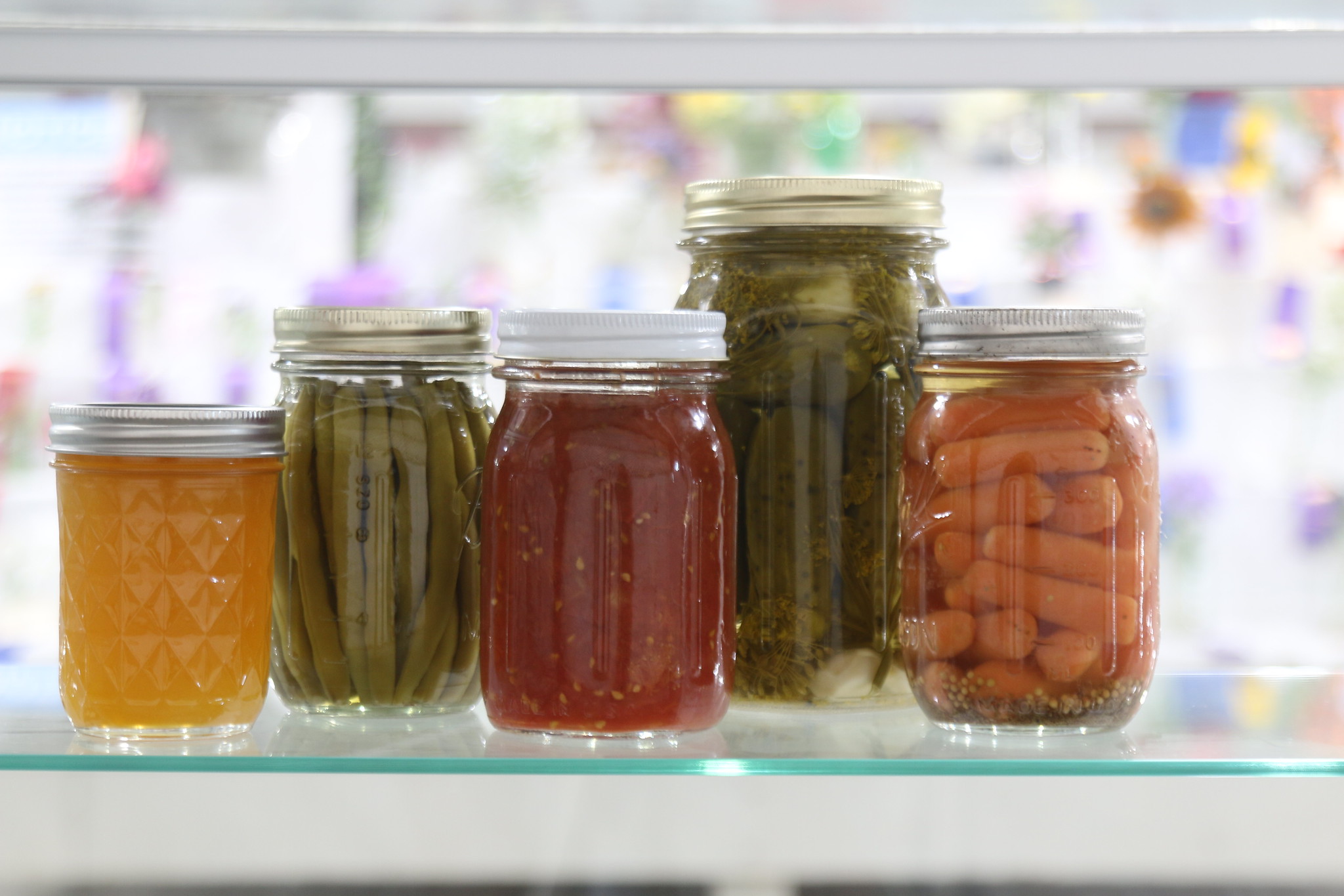 Five canning jars filled with different vegetables