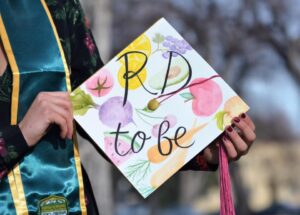 Guy's graduation cap which has painted fruits and vegetables with the words "RD to be" painted on top