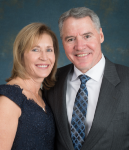 A woman and man pose for an event portrait at a gala.