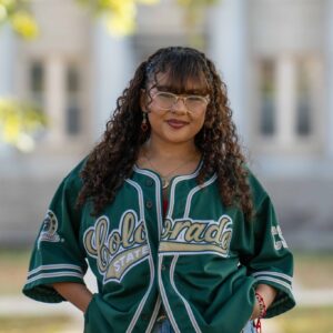 Maria smiles in the Oval wearing a CSU baseball jersey.