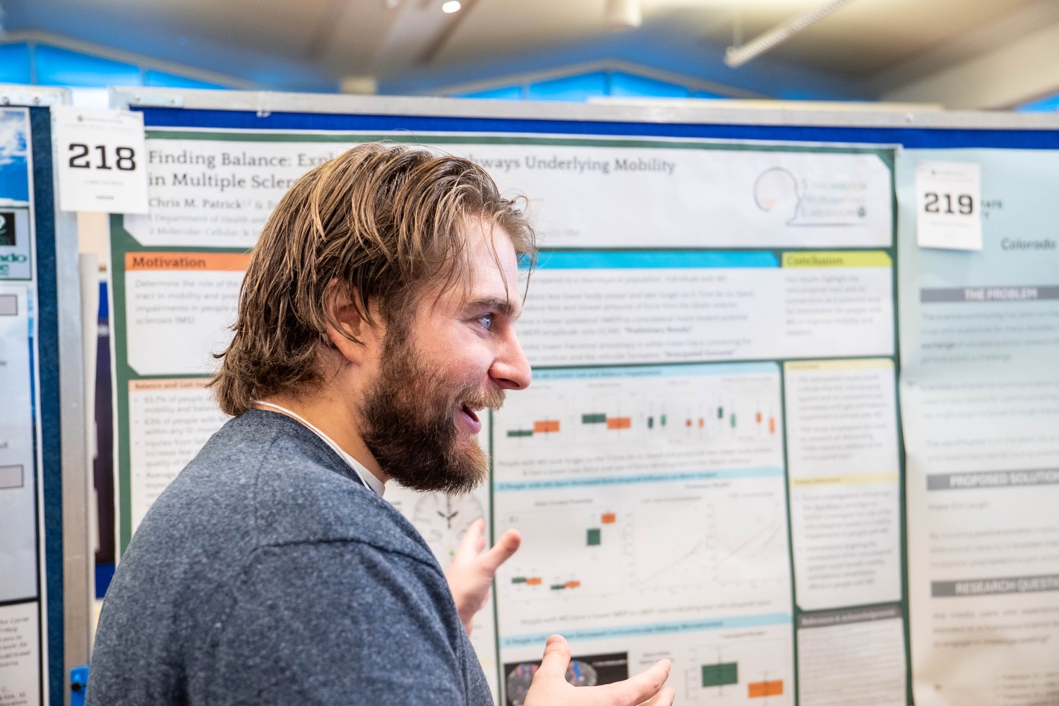 Chris Patrick standing in front of a research poster talking
