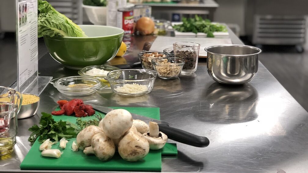 A collection of ingredients on cutting boards in an industrial kitchen.