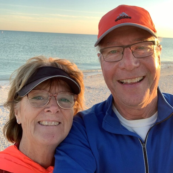 The Seasers smile for a selfie with the sunset beach behind them.
