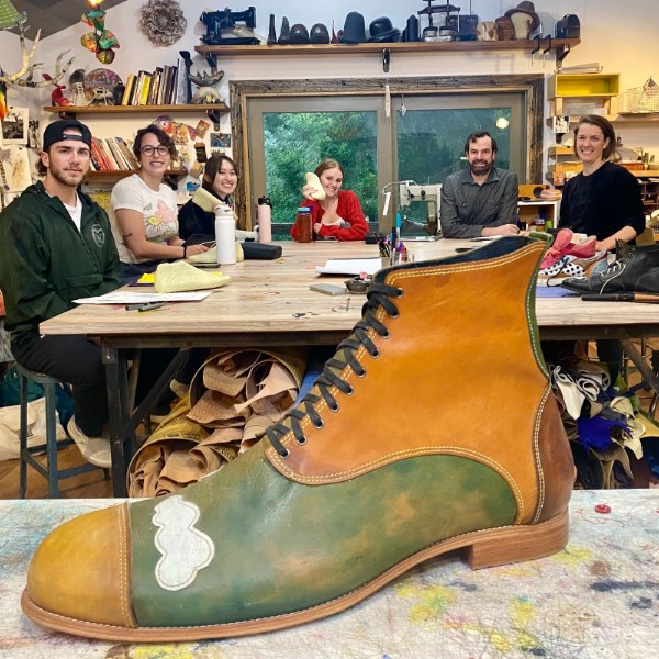 A group of people set in the background behind a shoe.