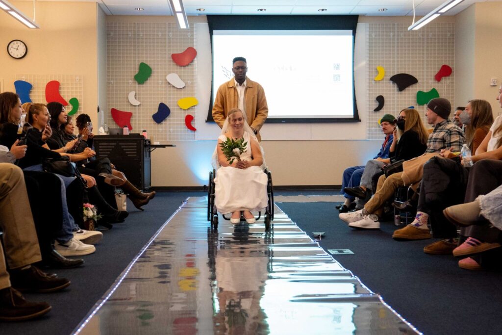 Libby moves down the runway in her wheelchair while wearing her custom designed wedding dress.