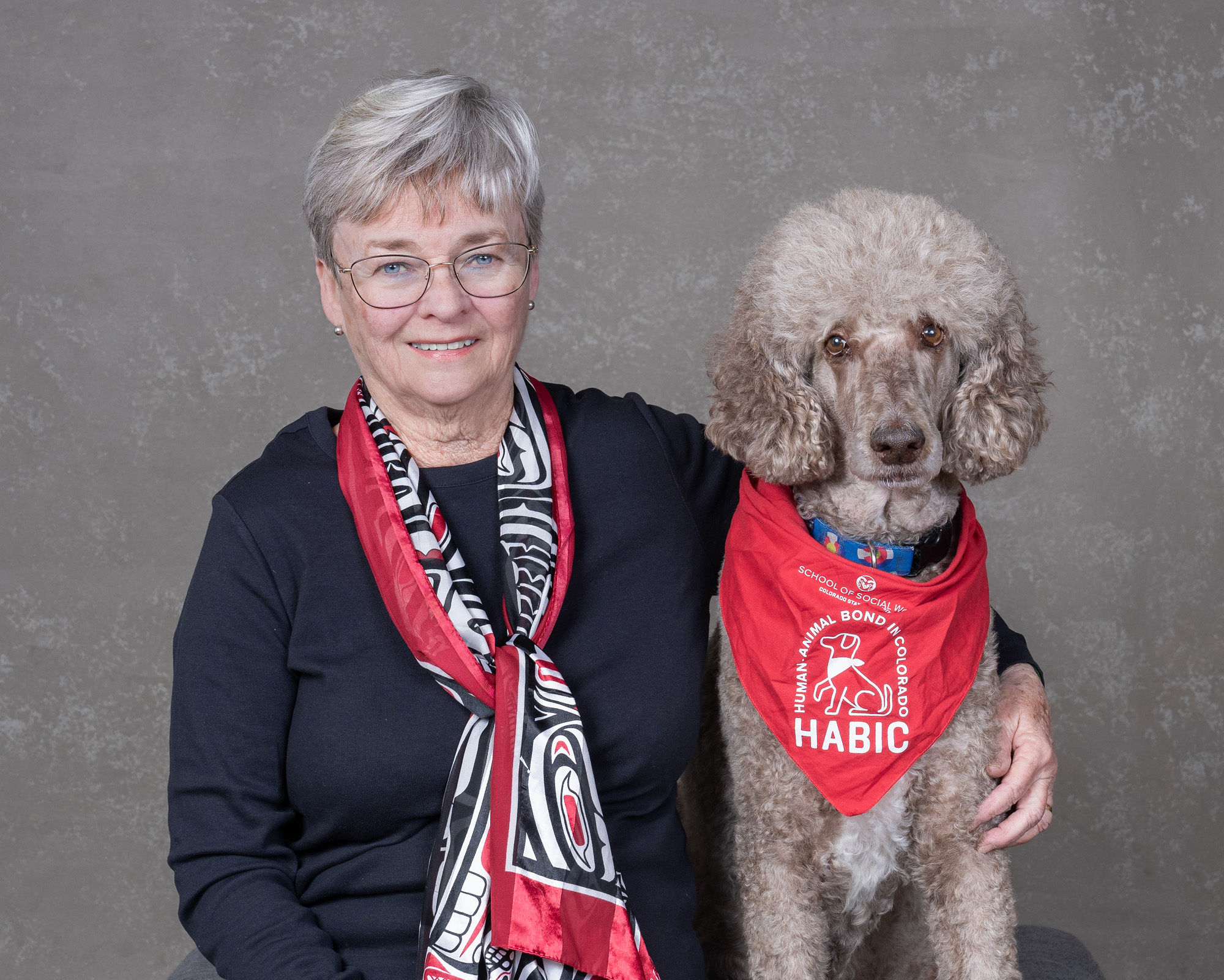 human-animal bond in colorado volunteer and her light grey standard poodle icy