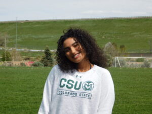 Hanna standing in the middle of a field with a CSU sweater on.