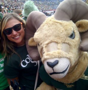 Acuff smiles with the Cam the Ram mascot at a football game.