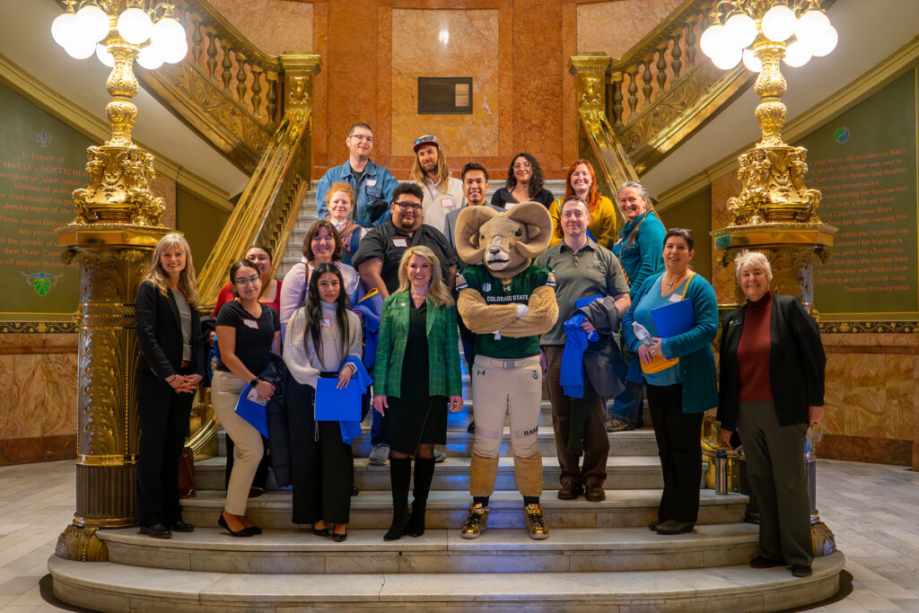 CSU Social Work students and faculty on a large staircase inside the Colorado state Capitol with representatives Kipp and Boesenecker, and CSU president Amy Parsons and Cam the Ram