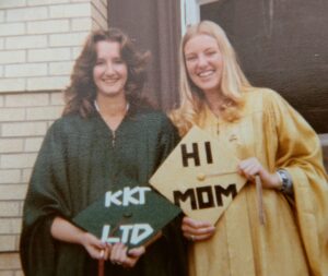 Michele and a friend pose in their graduation gowns.