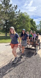 Tull and Grieb pull kids in a wagon along a rocky road