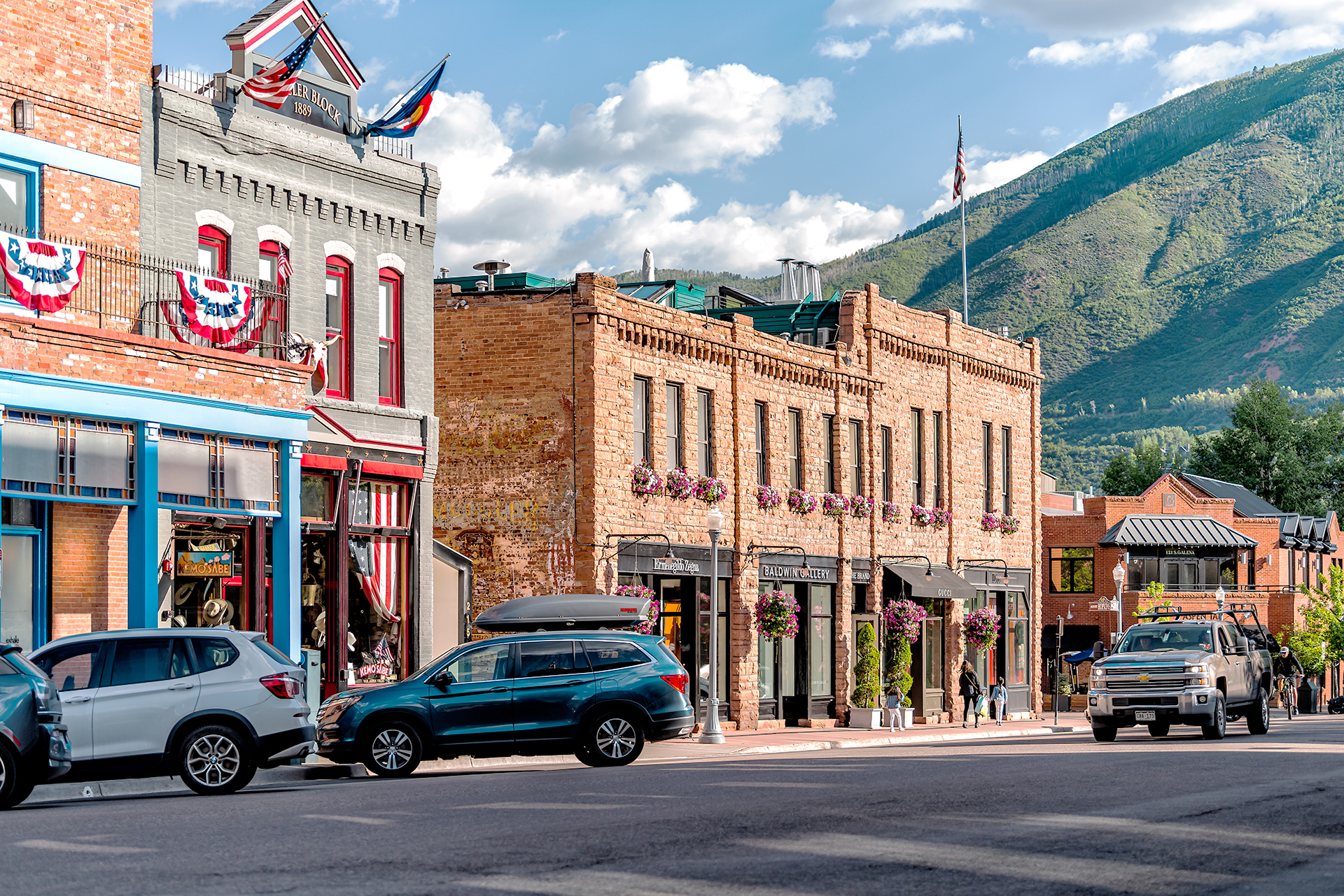 The photo shows a street photo from Aspen, Colorado, with two-story buildings and cars parked along the road.