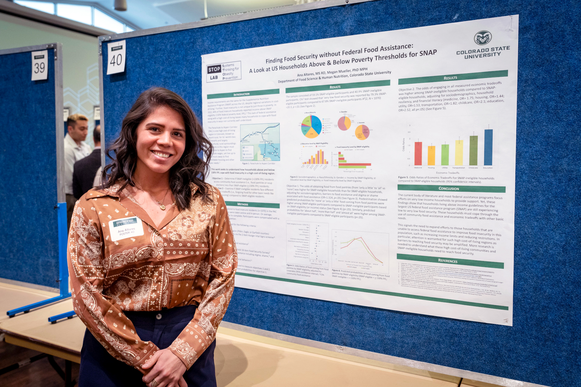 Ph.D. candidate Ana Altares stands in front of her Research Day poster about food insecurity in the Aspen region.