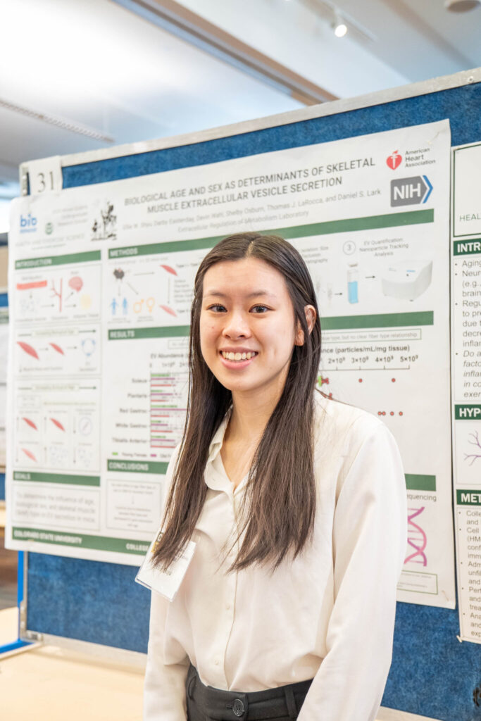 Shyu stands in front of their poster of their AQ research at CURC
